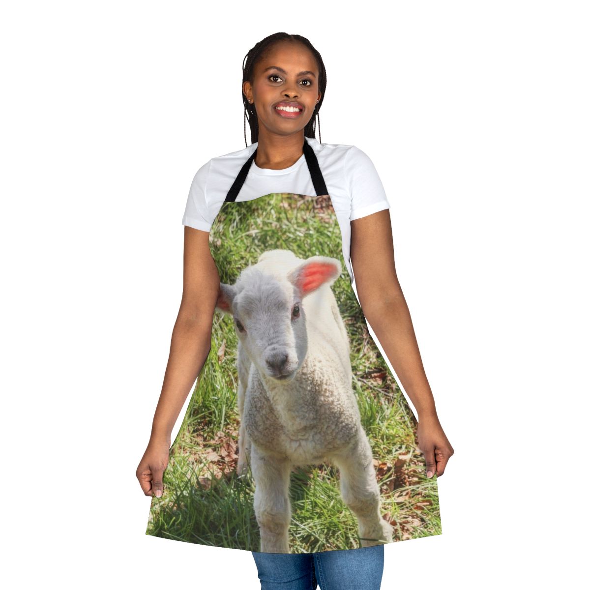 A close-up photo of a cute, young baby lamb standing in a grassy, pastoral setting.