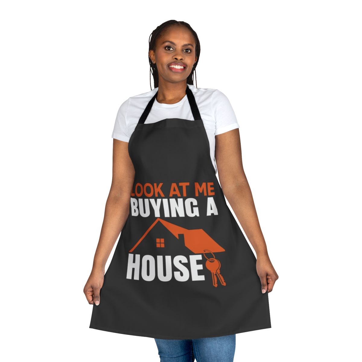 Man wearing a "Look at Me Buying a House" themed apron in his kitchen