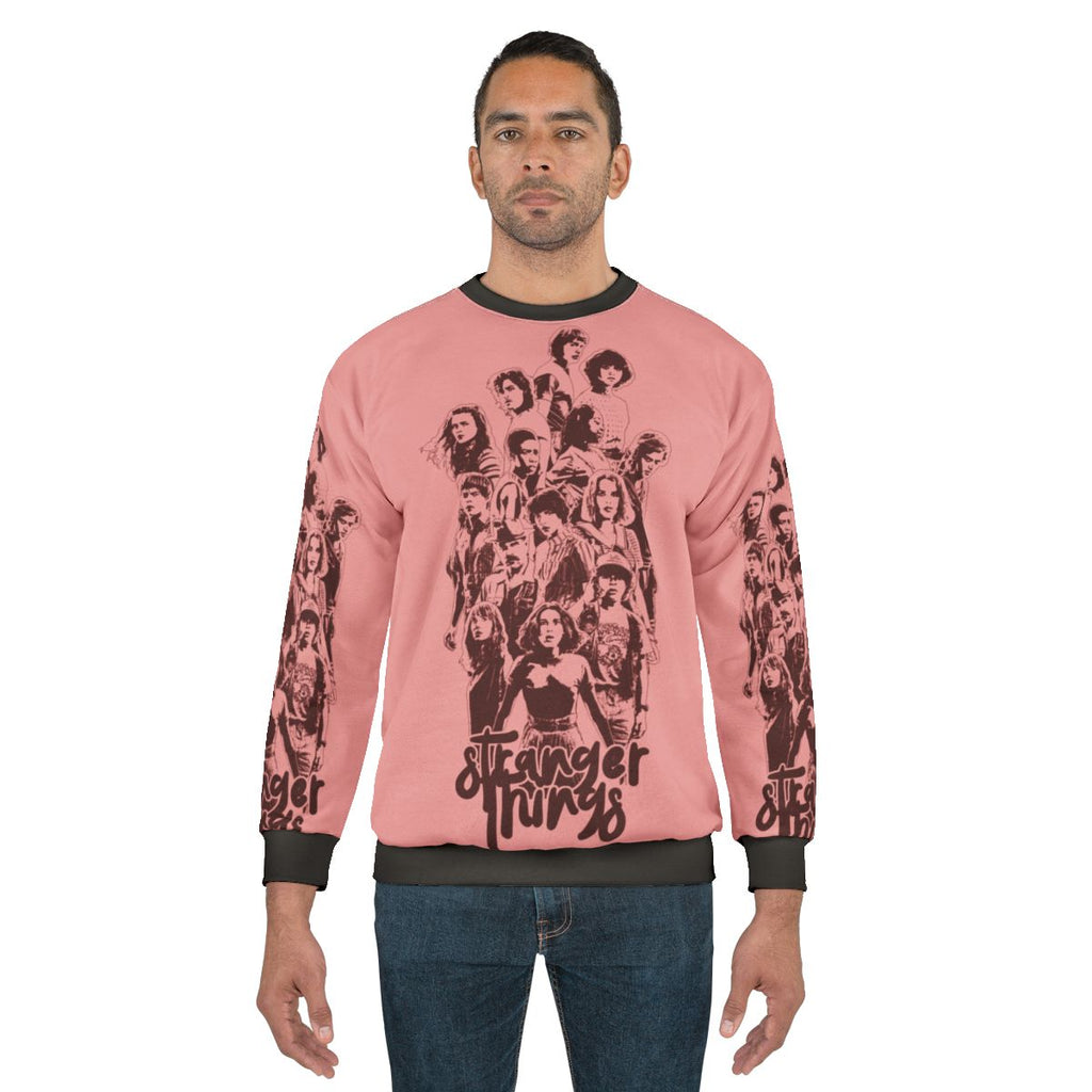 Eleven from Stranger Things wearing a 3 times stranger sweatshirt