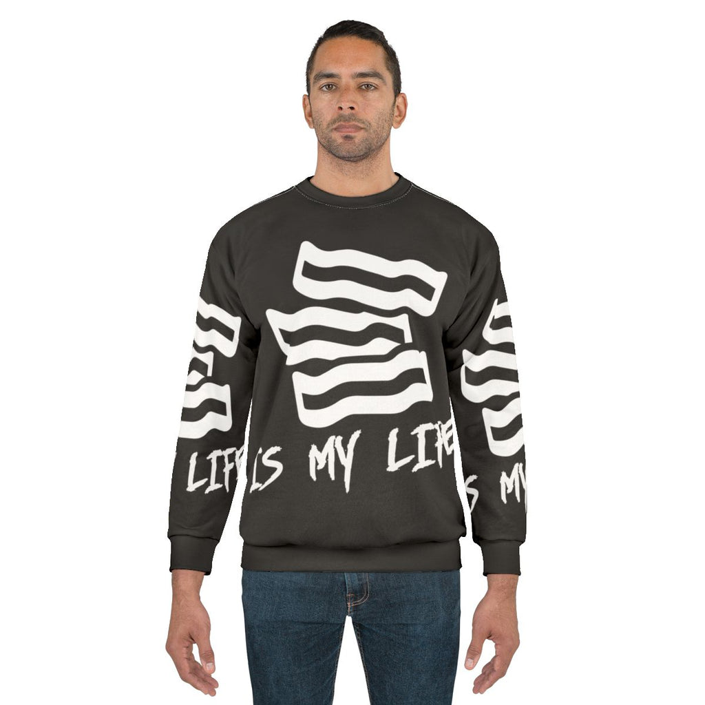 Bacon lover wearing a sweatshirt with "Bacon Is My Life" printed on it