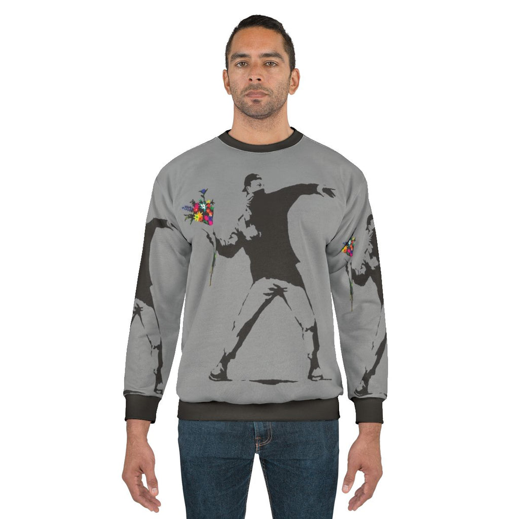 Banksy inspired sweatshirt featuring protester throwing flowers graphic
