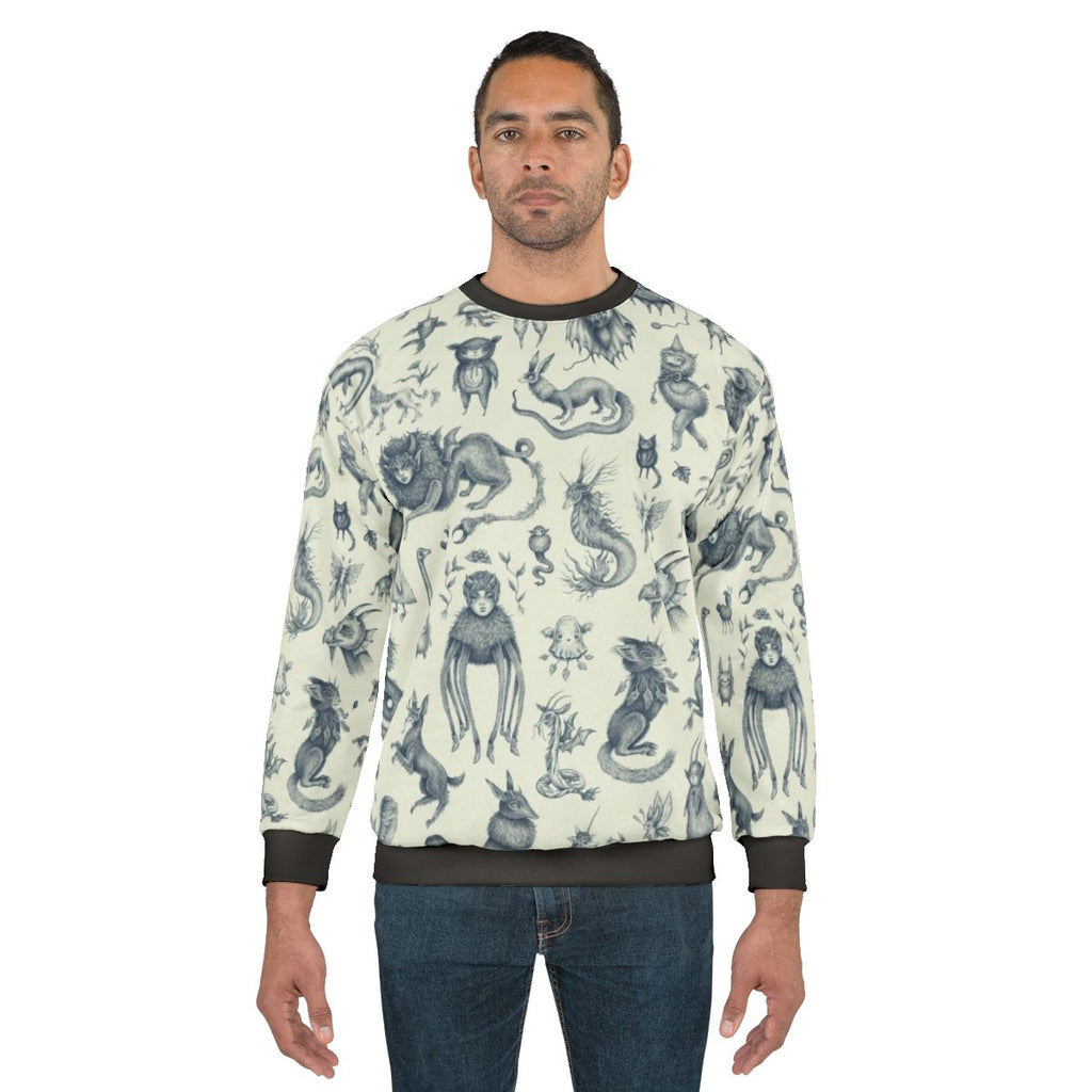 Sweatshirt with a pattern of mythical creatures like Bigfoot, Nessie, and dragons in a pastel, nature-inspired design