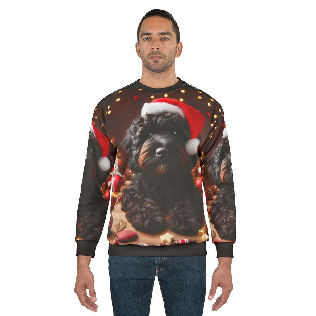 Black cockapoo dog wearing a Santa hat on a Christmas sweatshirt