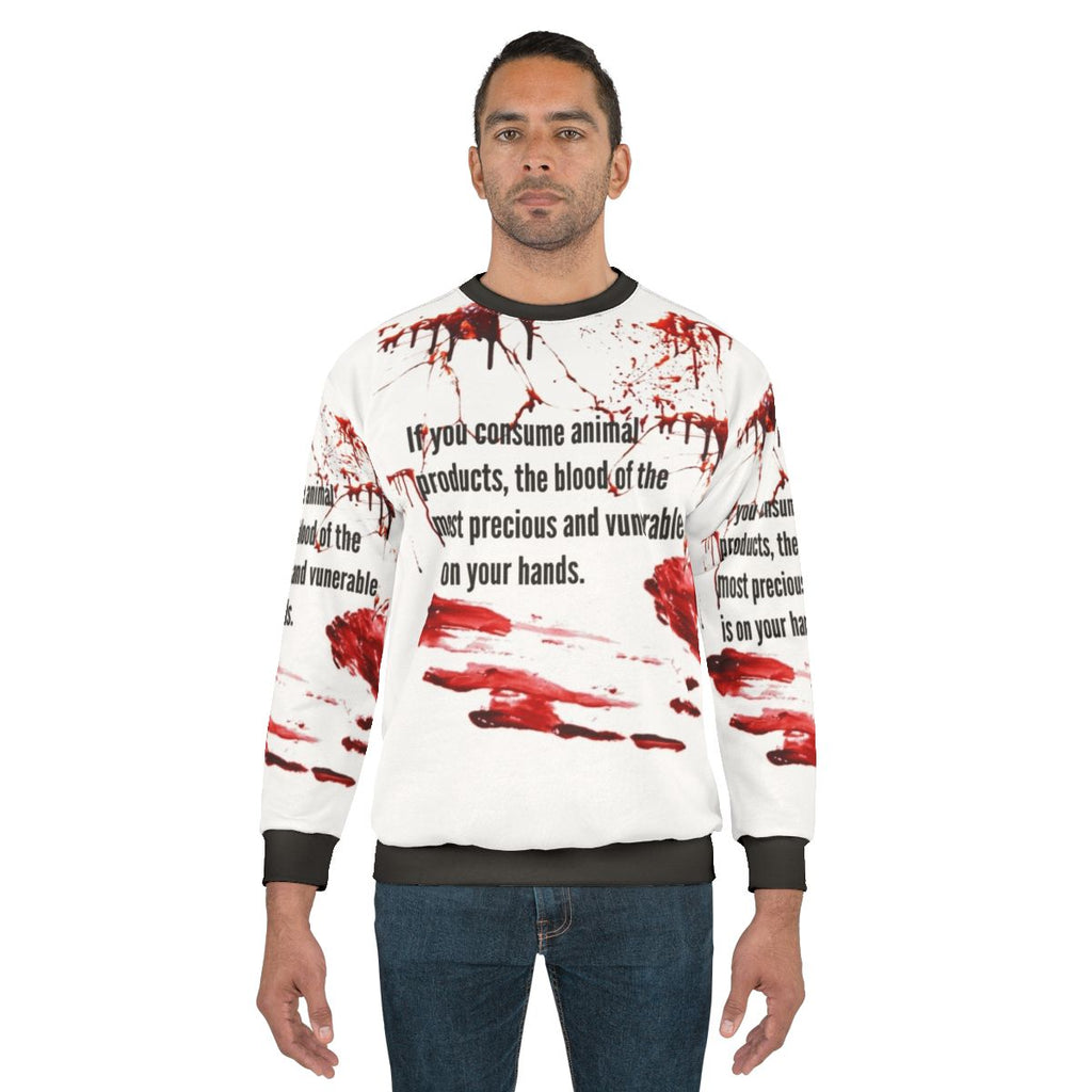 Animal rights activist wearing vegan sweatshirt with "Blood Is On Your Hands" message