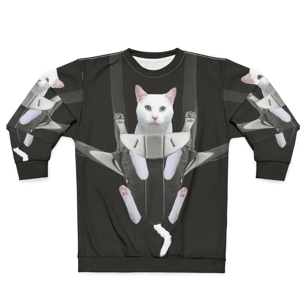 Tabby cat snuggling in a baby carrier on a white sweatshirt