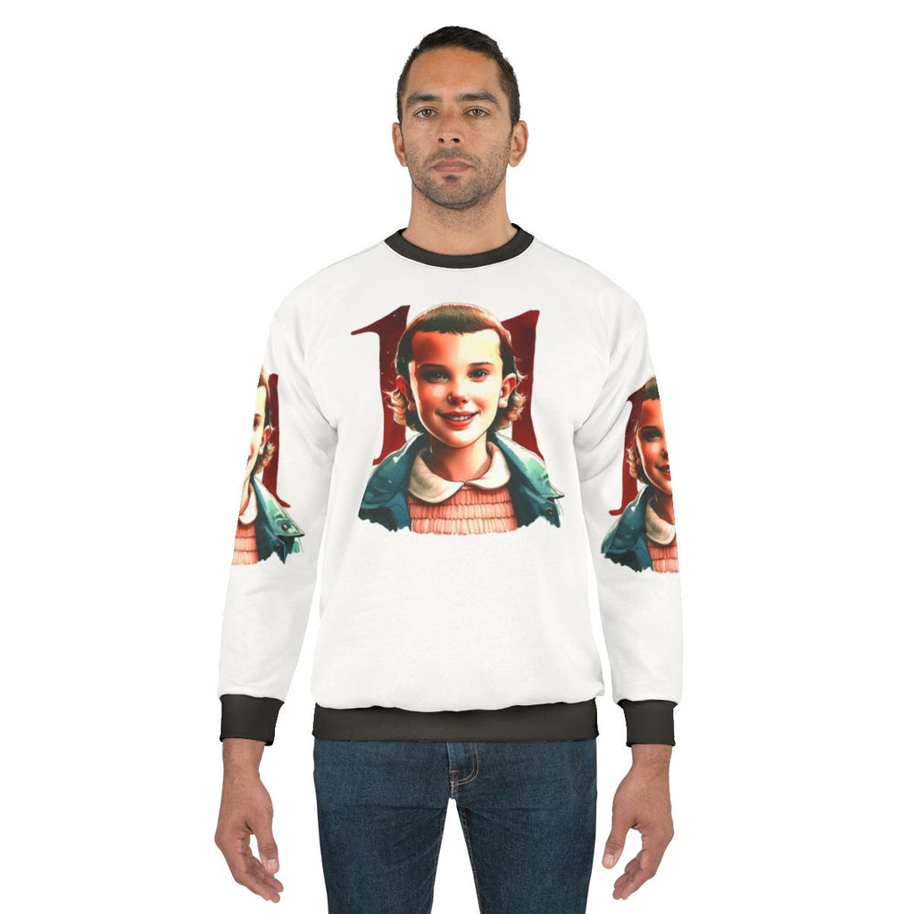Eleven from Stranger Things wearing the official Eleven Stranger Things Sweatshirt