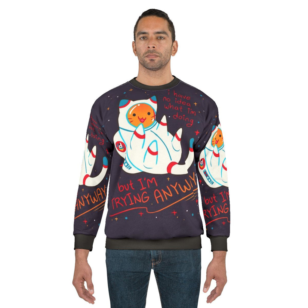 Cat astronaut wearing a cozy sweatshirt with a positive affirmation