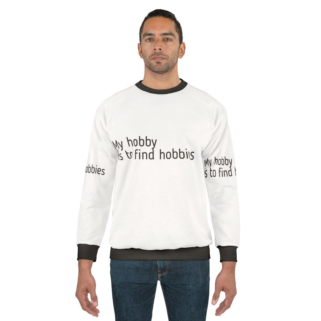 A person wearing a sweatshirt that reads "My Hobby Is To Find Hobbies"
