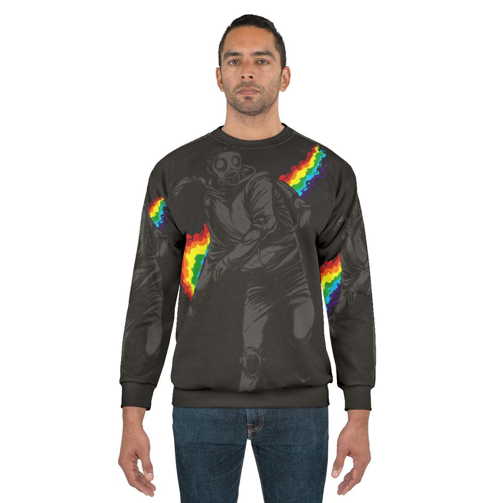 Colorful sweatshirt design with text "No More Tear Gas" against a background of political protest imagery