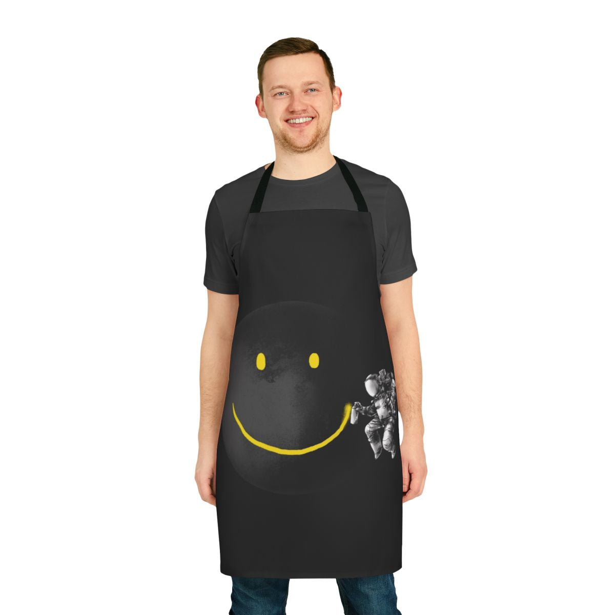 Black and white abstract art apron with a surreal, smiling astronaut design on a moon background.