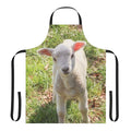 A close-up photo of a cute, young baby lamb standing in a grassy, pastoral setting.