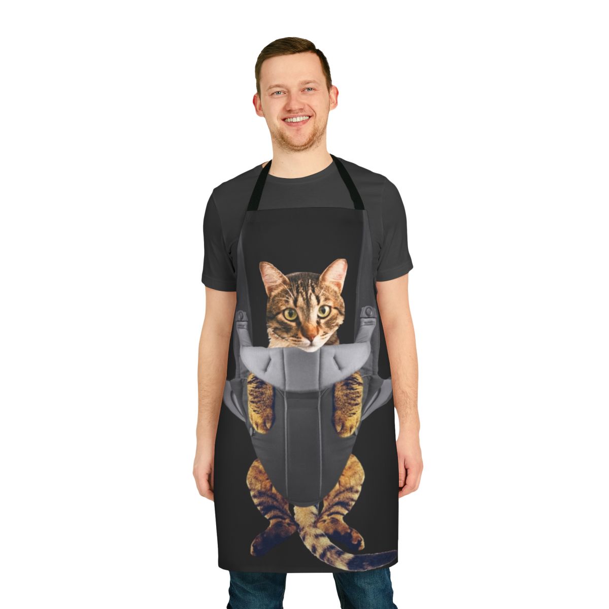Tabby cat cozily nestled in a baby carrier-style apron, creating a humorous and heartwarming image.