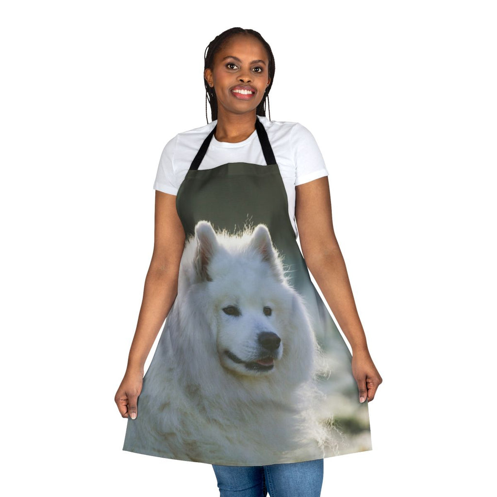 A white fluffy Samoyed dog wearing an apron with a smiling expression