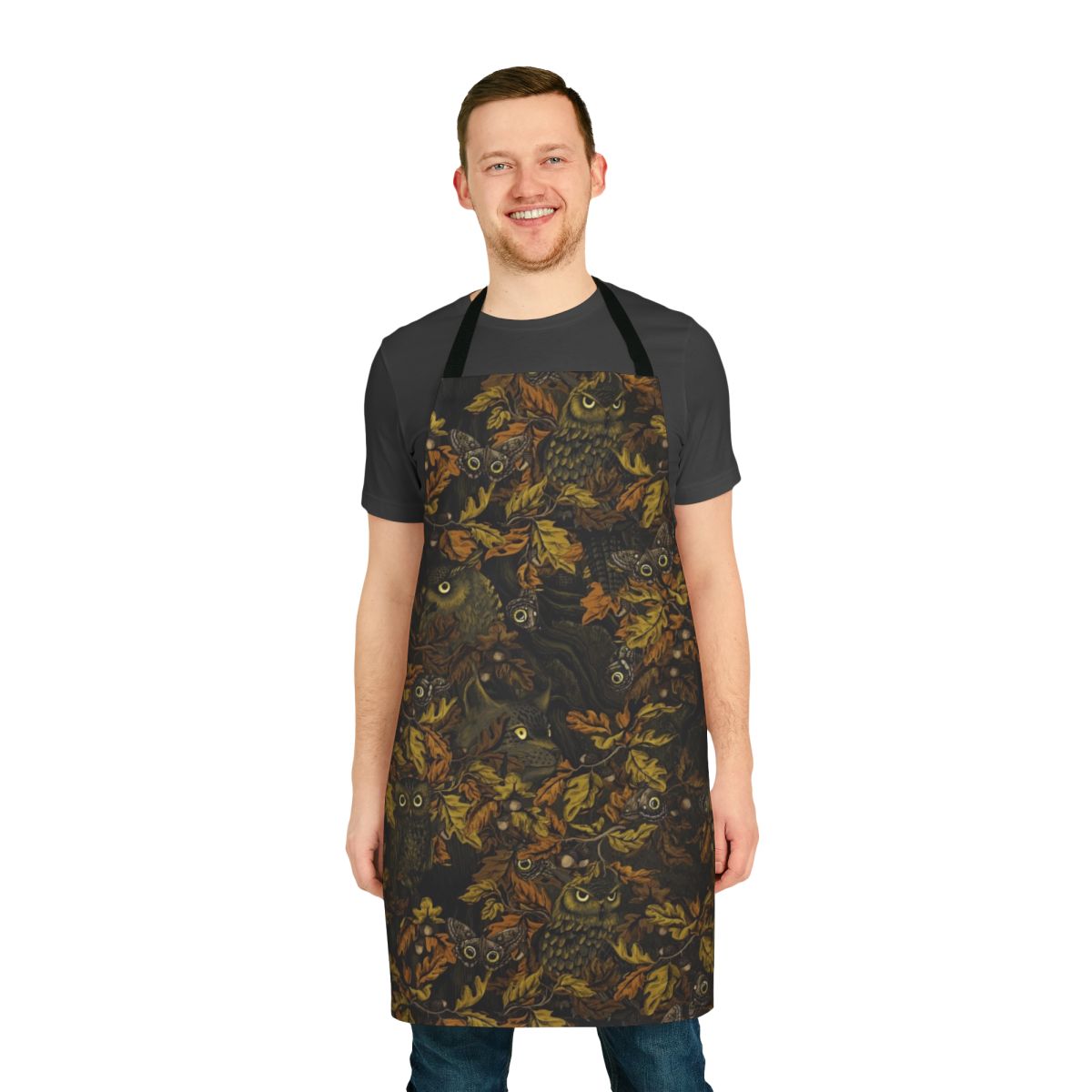 A rustic, nature-inspired apron featuring a camouflage pattern with autumn leaves, owls, and other forest elements.