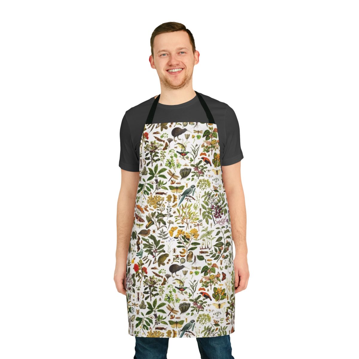 A colorful apron featuring a detailed, seamless pattern of native New Zealand flora and fauna, including butterflies, birds, and botanical elements.