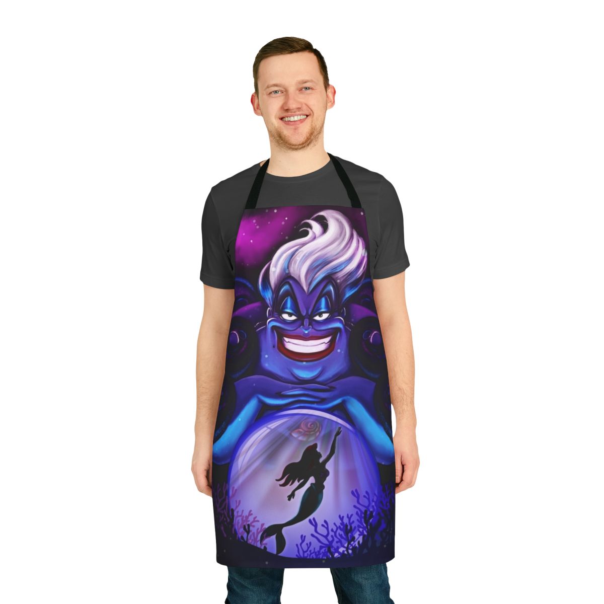 An apron featuring Ursula, the sea witch from Disney's The Little Mermaid, with her iconic crystal ball and ocean-themed design.