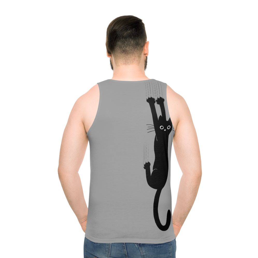Black cat hanging on to tank top