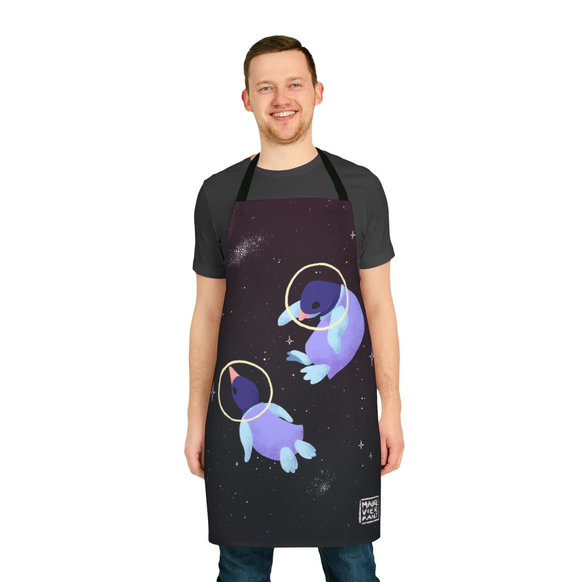 Whimsical apron featuring a cute penguin in an astronaut suit against a starry galaxy background