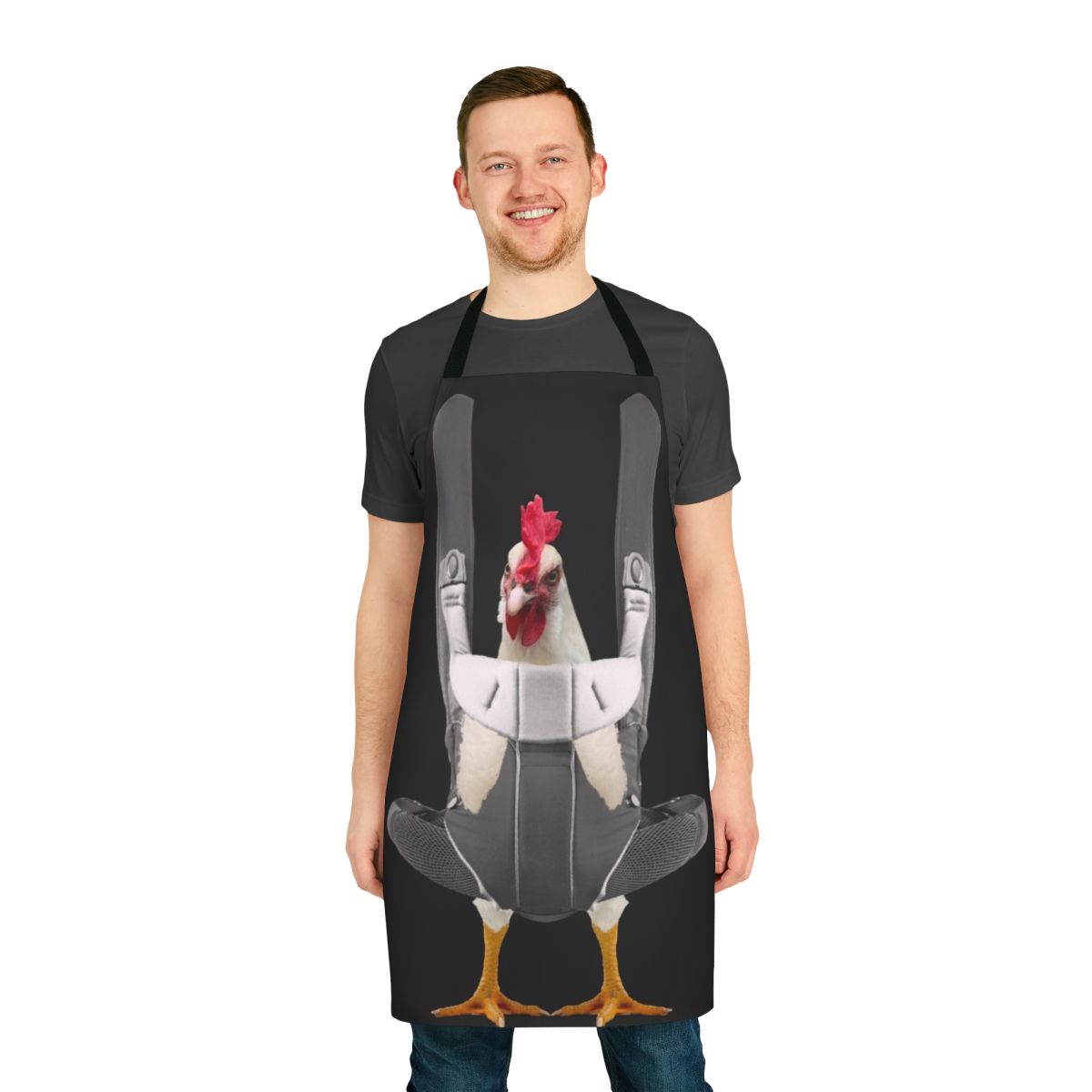 Person wearing an apron with a chicken design, carrying a chicken in a baby carrier