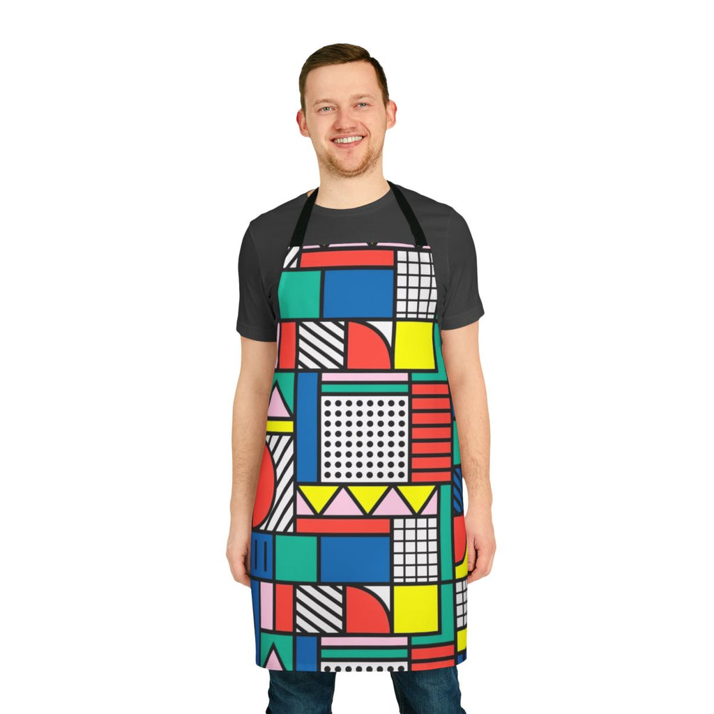 A vibrant, color block apron featuring a retro-inspired geometric pattern in shades of blue, pink, and yellow.