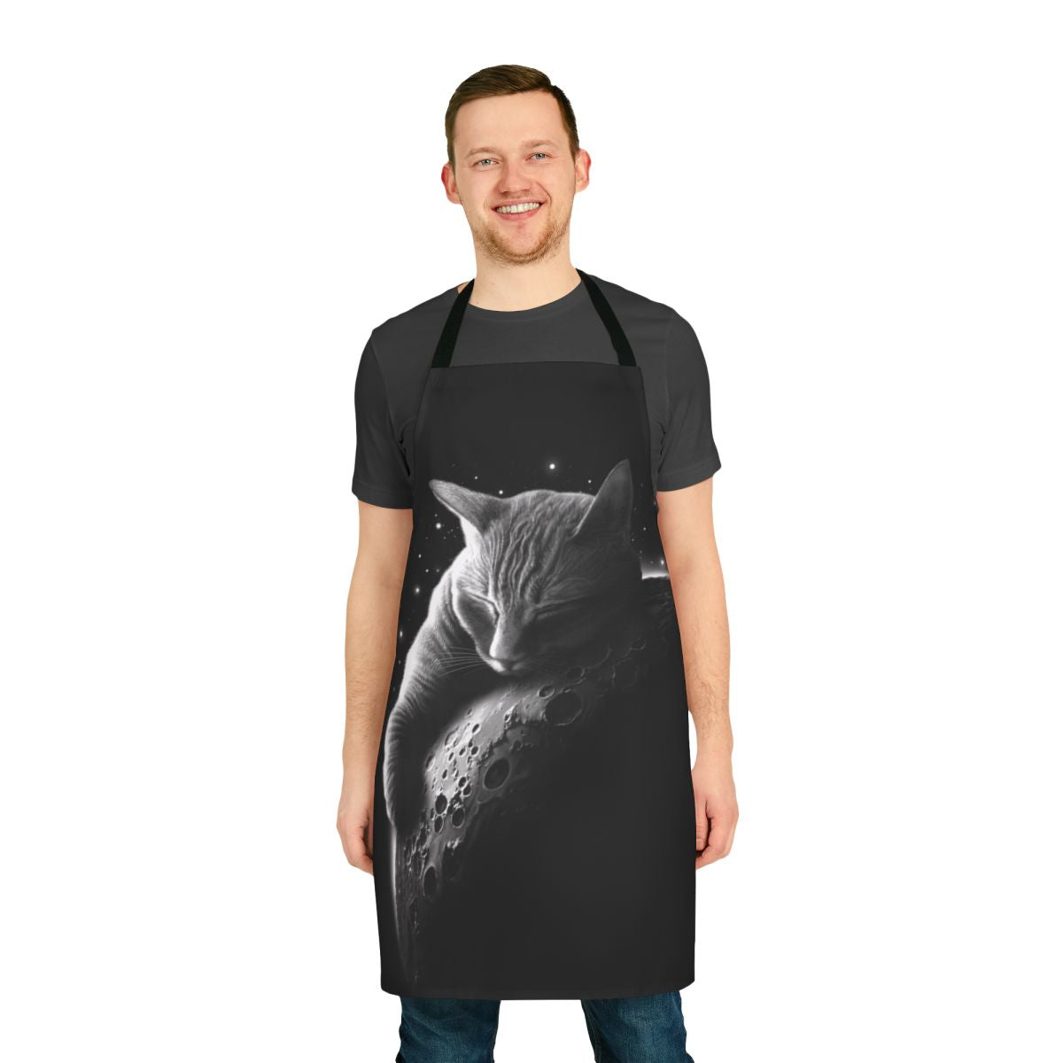 A stylish and whimsical black apron featuring a cat astronaut silhouette against a crescent moon and starry space backdrop