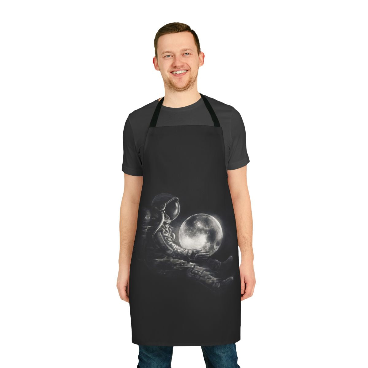 Black and white image of an apron with a surreal, space-inspired design featuring planets, stars, and an astronaut silhouette.