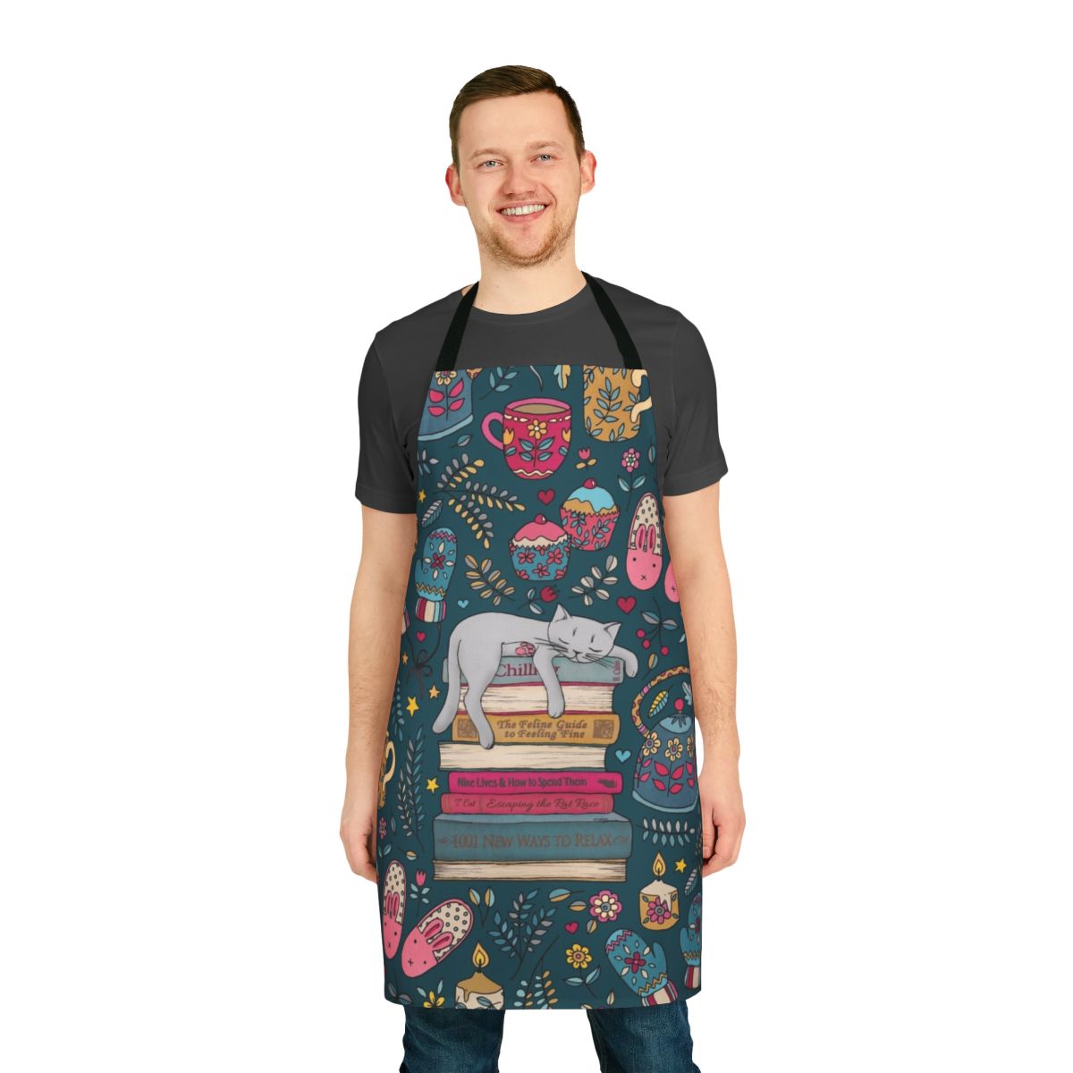 A dark green and pink apron with a cute cat sleeping on a book design, perfect for embracing the hygge lifestyle.