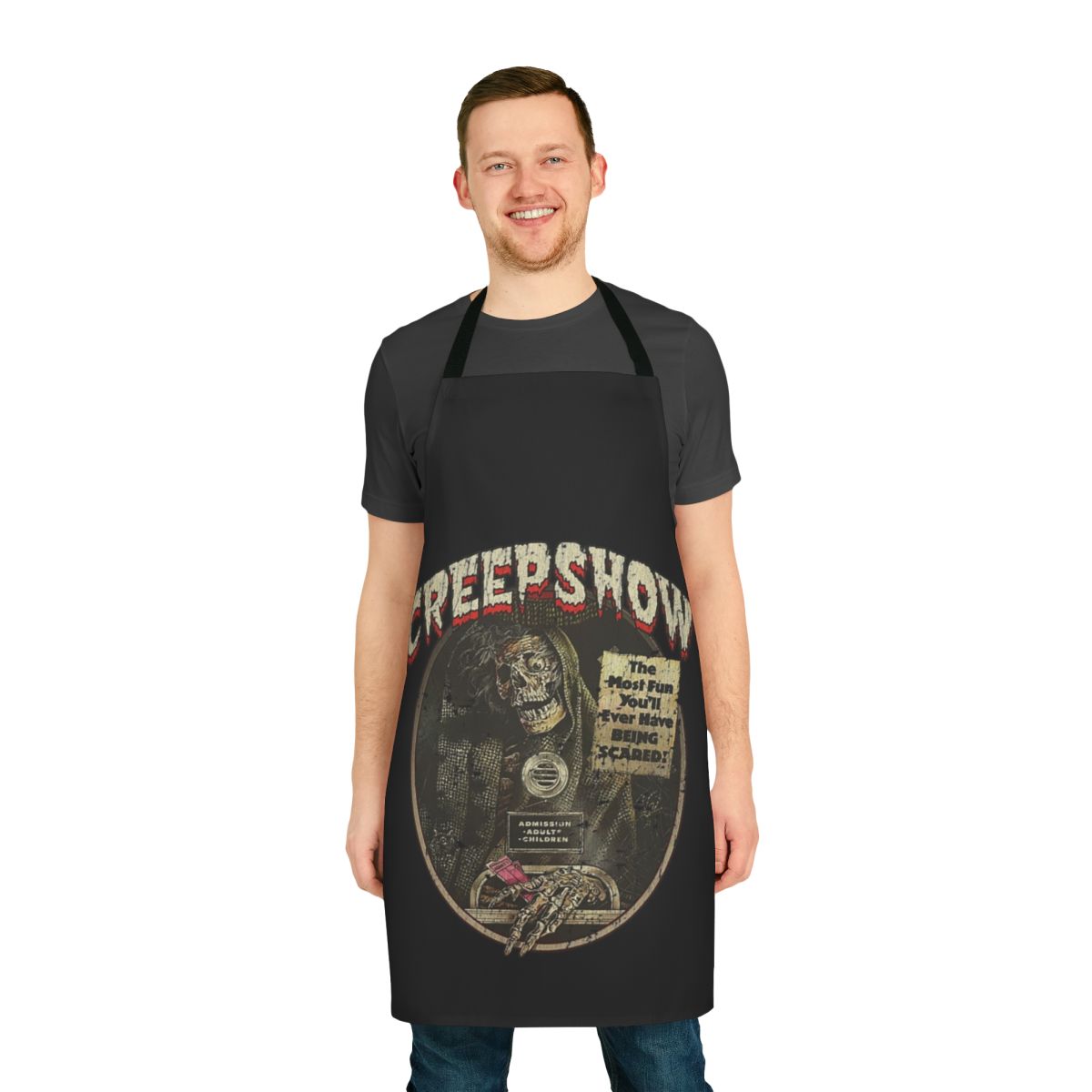 A black apron featuring a spooky skeleton and skull design inspired by the 1982 horror movie Creepshow.