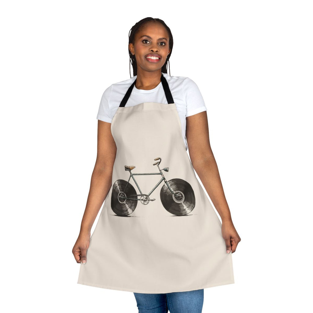 A colorful apron featuring musical notes, bikes, and vinyl records, perfect for kitchen or workshop use.