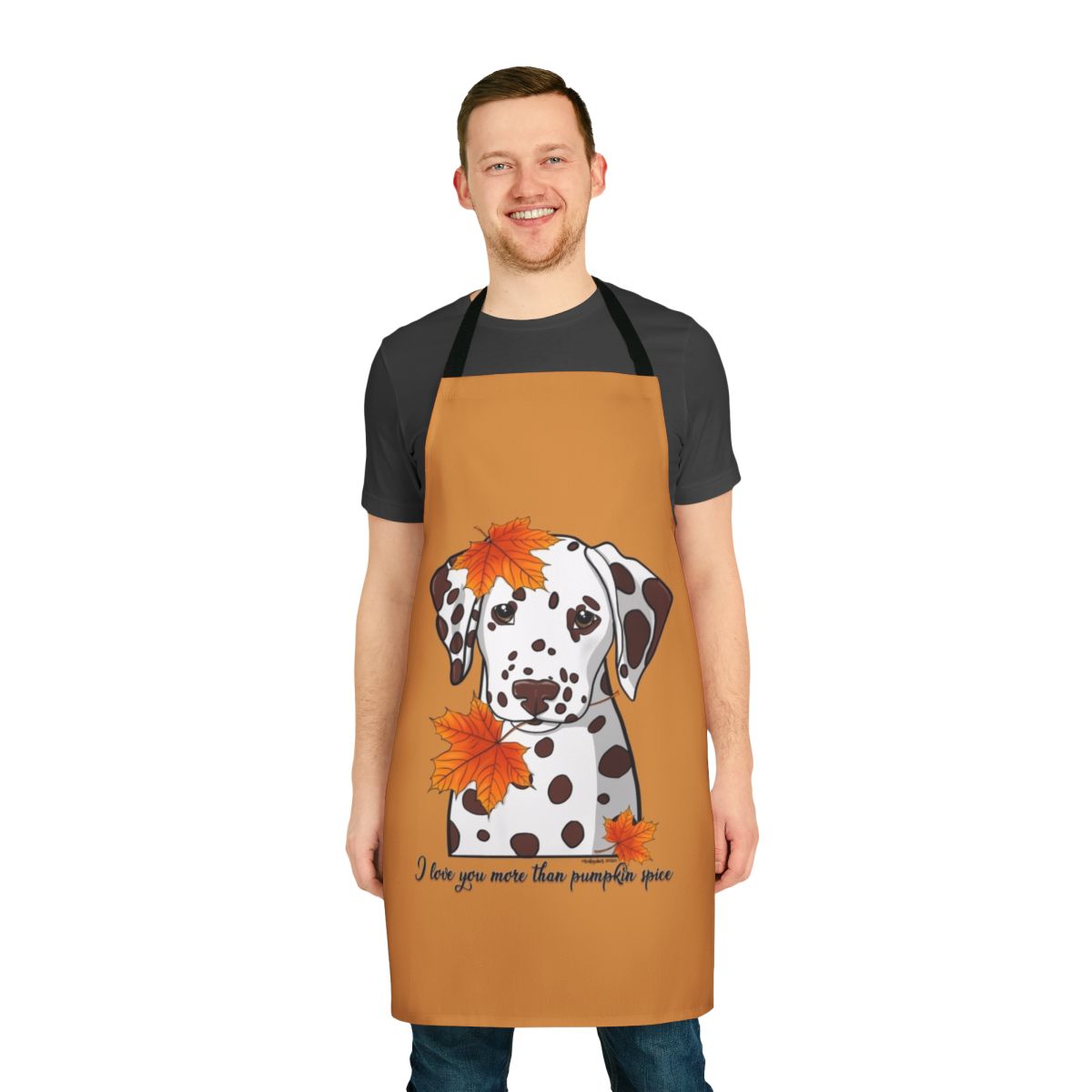 A white and black dalmatian dog wearing an apron with fall leaves and pumpkin spice designs.