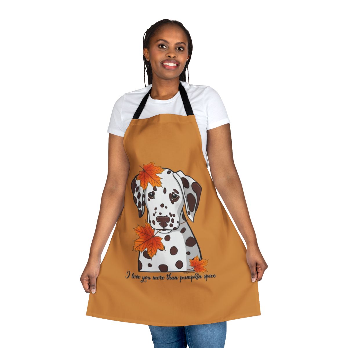 A white and black dalmatian dog wearing an apron with fall leaves and pumpkin spice designs.