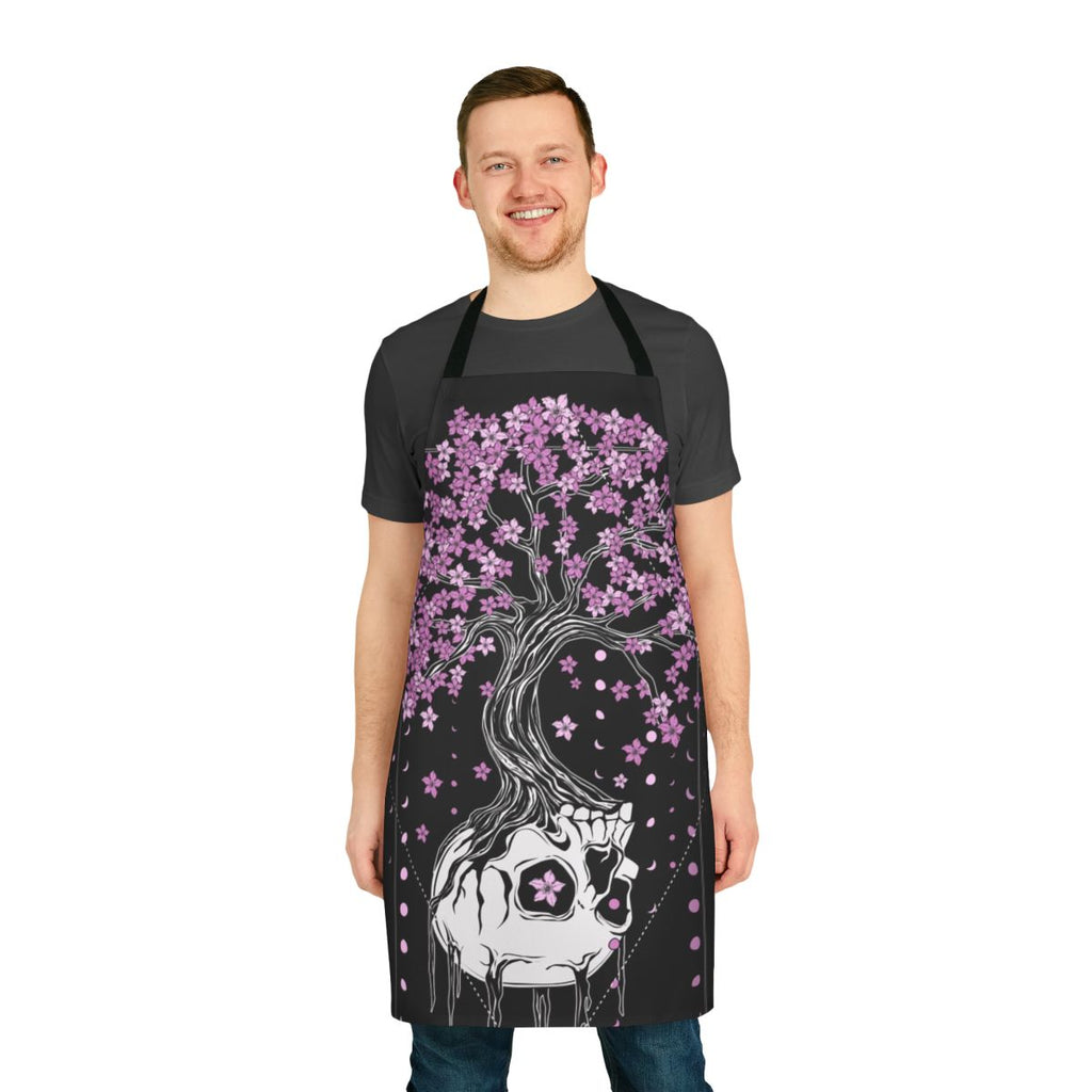 A black apron with a skull and cherry blossom design, a gothic and macabre style perfect for the kitchen.