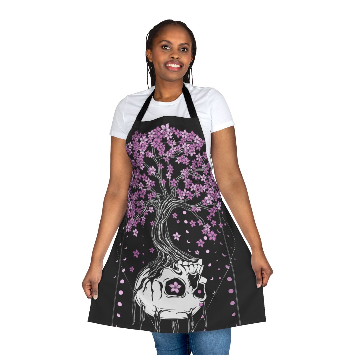 A black apron with a skull and cherry blossom design, a gothic and macabre style perfect for the kitchen.
