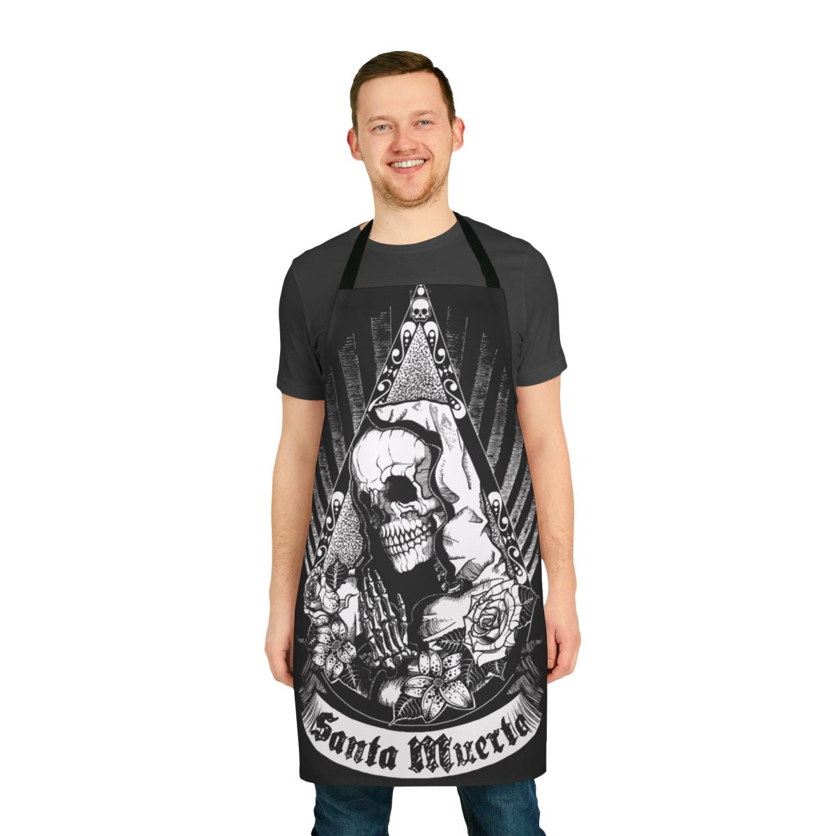 A black and white apron featuring a skull, skeleton, flowers, and the image of Santa Muerte, the Mexican folk saint.