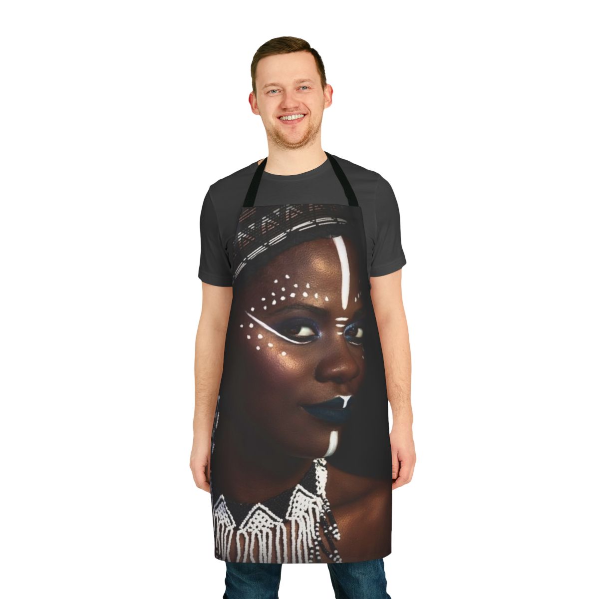 A decorative tribal-inspired apron featuring an abstract face design with gold dust and jewelry elements.