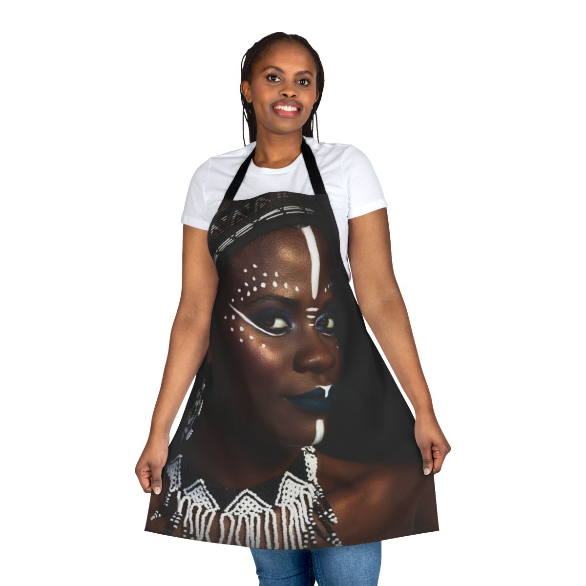 A decorative tribal-inspired apron featuring an abstract face design with gold dust and jewelry elements.