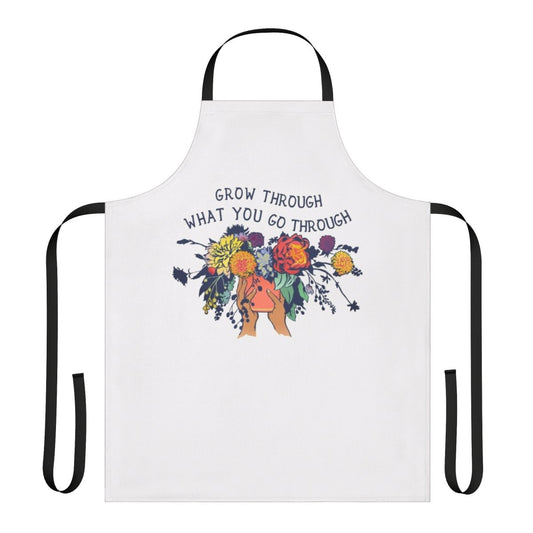 An apron with a floral bouquet design and the text "Grow Through What You Go Through"