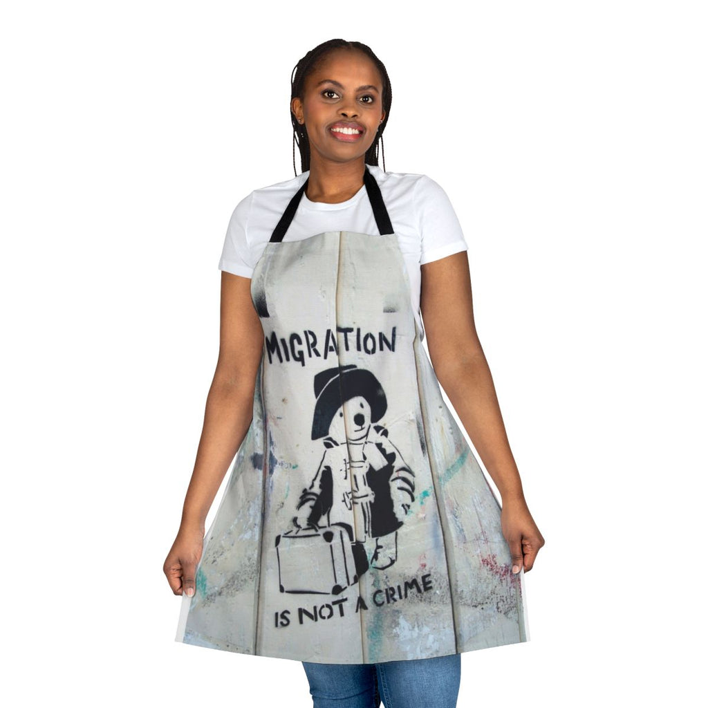 "Apron with the phrase 'Migration Is Not A Crime' in a graffiti-style design"