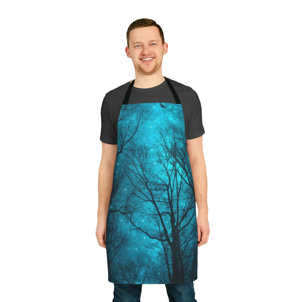 An apron featuring a dreamy night sky design with a galaxy print and silhouetted tree branches.