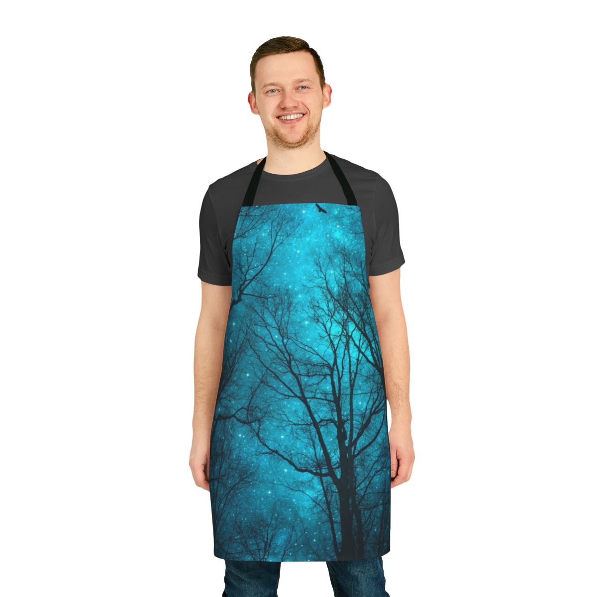 An apron featuring a dreamy night sky design with a galaxy print and silhouetted tree branches.