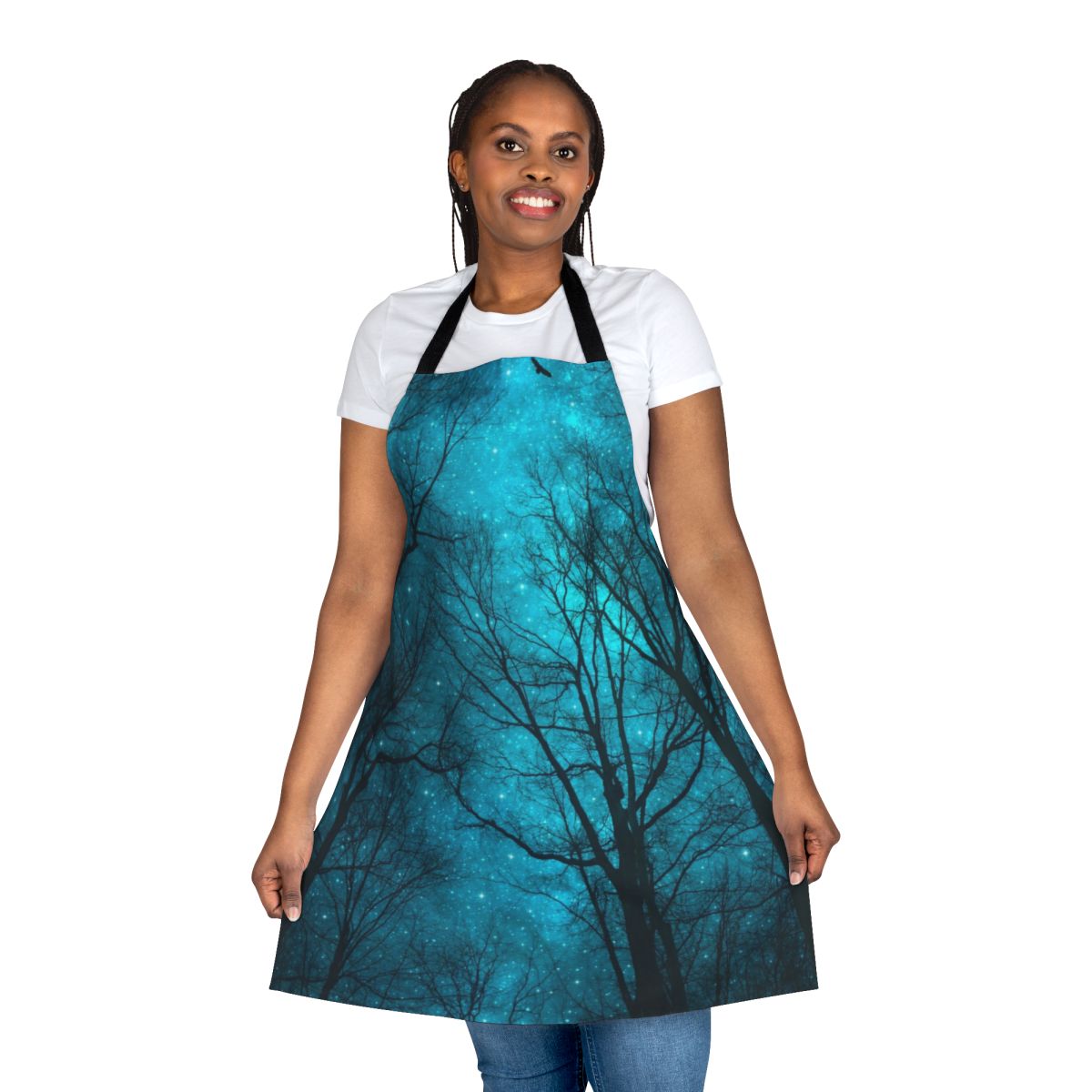 An apron featuring a dreamy night sky design with a galaxy print and silhouetted tree branches.