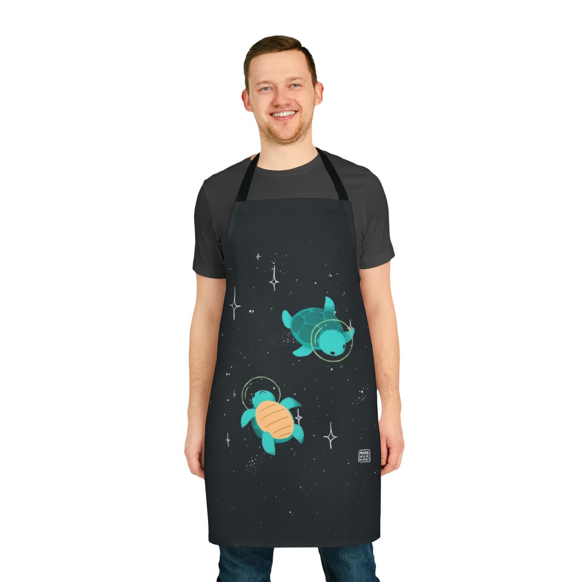 Apron featuring a design of a cute, green space turtle exploring the galaxy with stars and planets in the background.