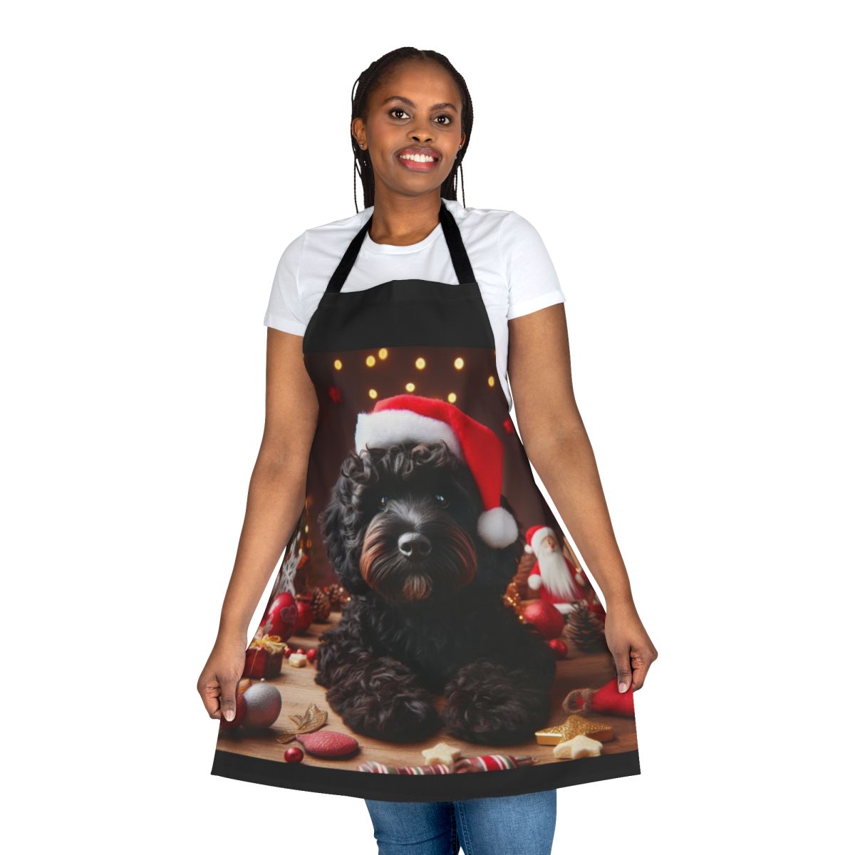 A black cockapoo dog wearing a Santa hat on a Christmas-themed apron