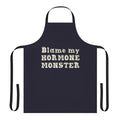 A black apron with an illustration of the Big Mouth hormone monster character from the Netflix animated series.