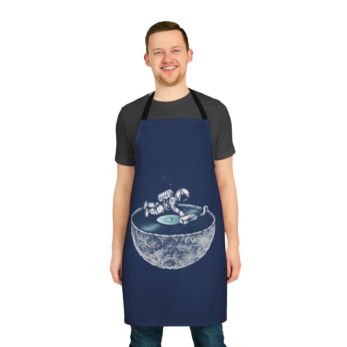 Person wearing a denim apron with a space and music themed design