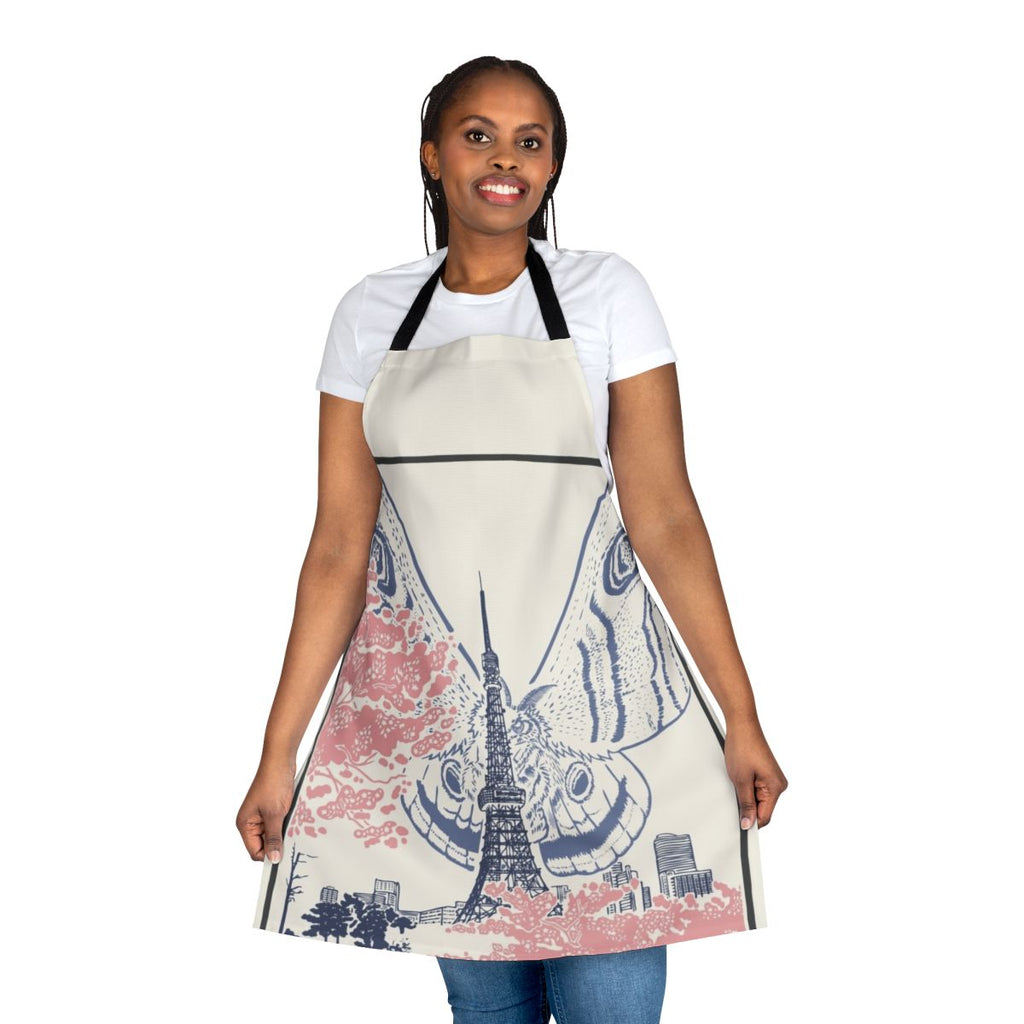 An apron featuring a giant moth creature perched on the iconic Tokyo Tower against a Japanese city skyline.