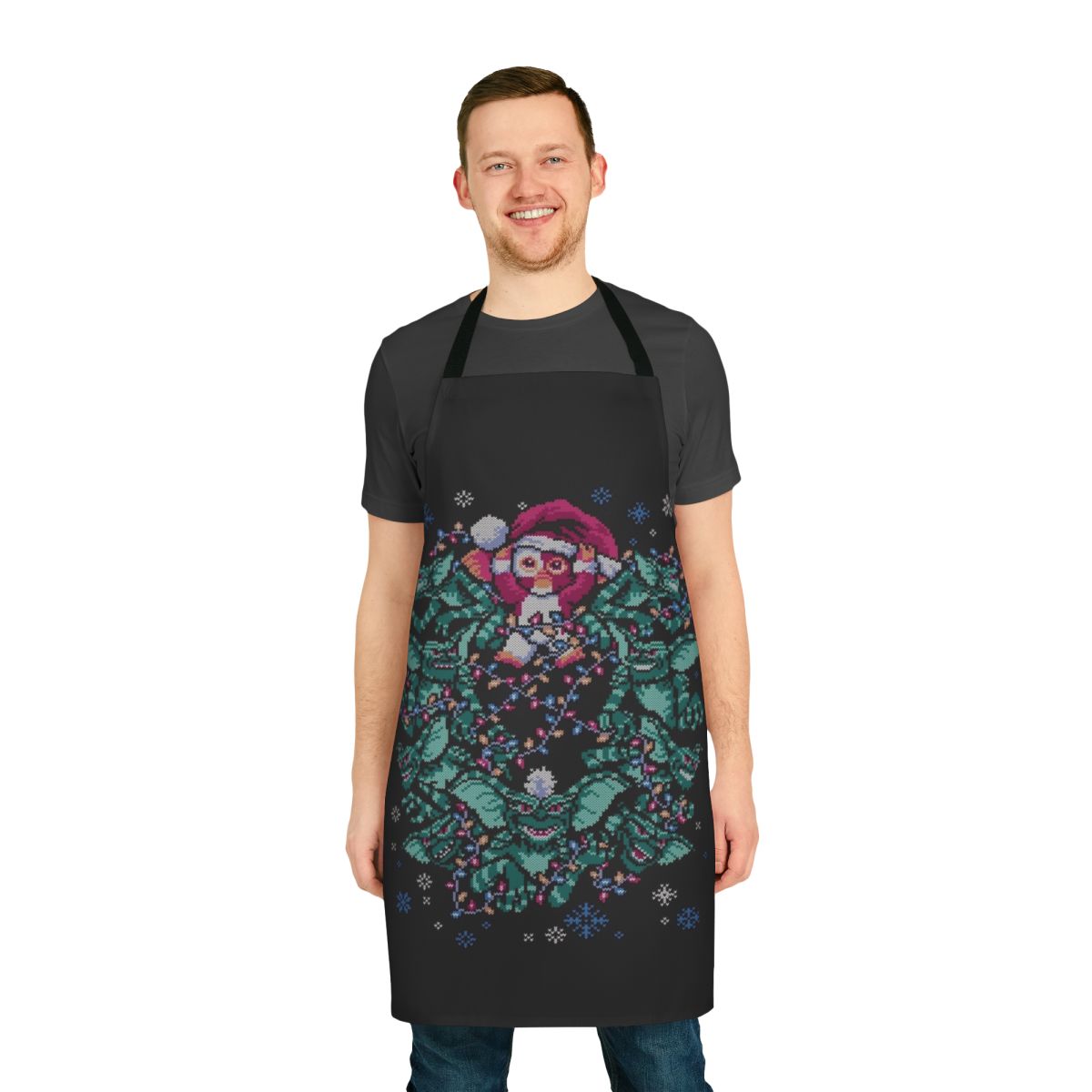 An apron featuring a gremlin-inspired Christmas design with a retro 80s horror movie theme.