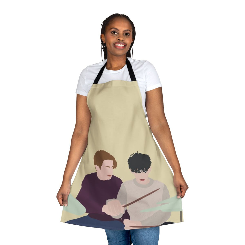 Heartstopper-themed apron featuring illustrations of Nick and Charlie playing drums