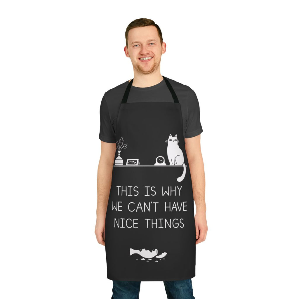A white apron with a black and white typographic design that reads "This Is Why We Can't Have Nice Things" against a backdrop of a broken vase or plant.