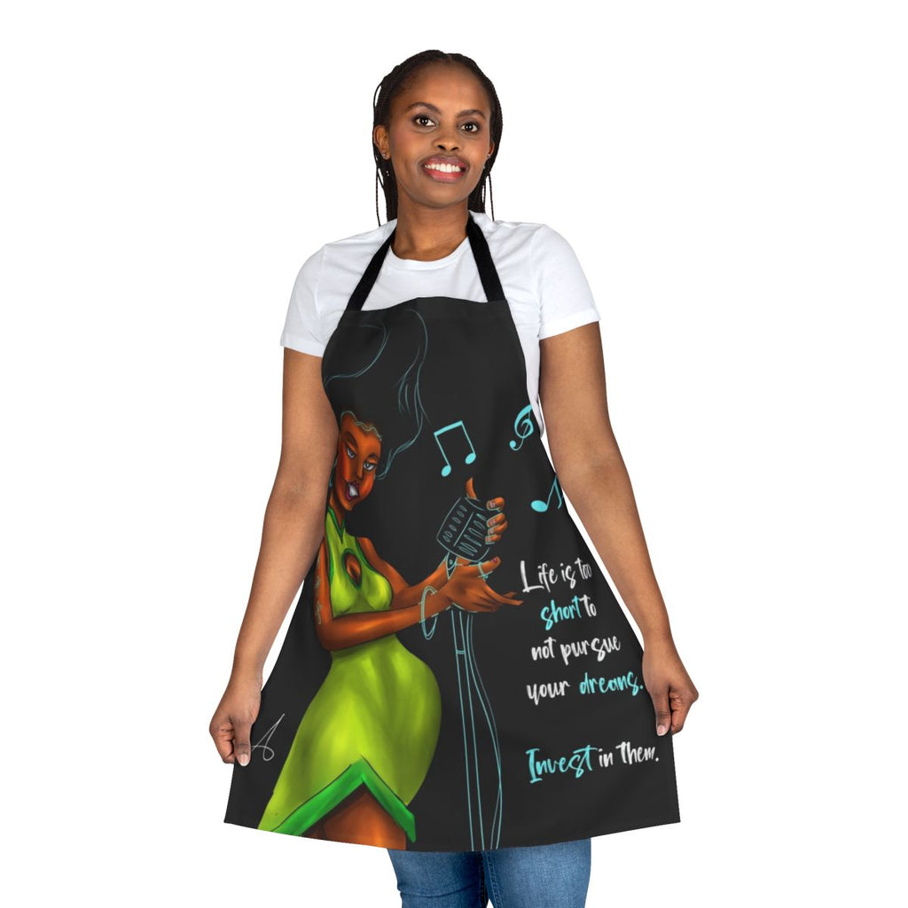A green apron with an inspirational woman singing into a microphone, featuring a motivational quote.